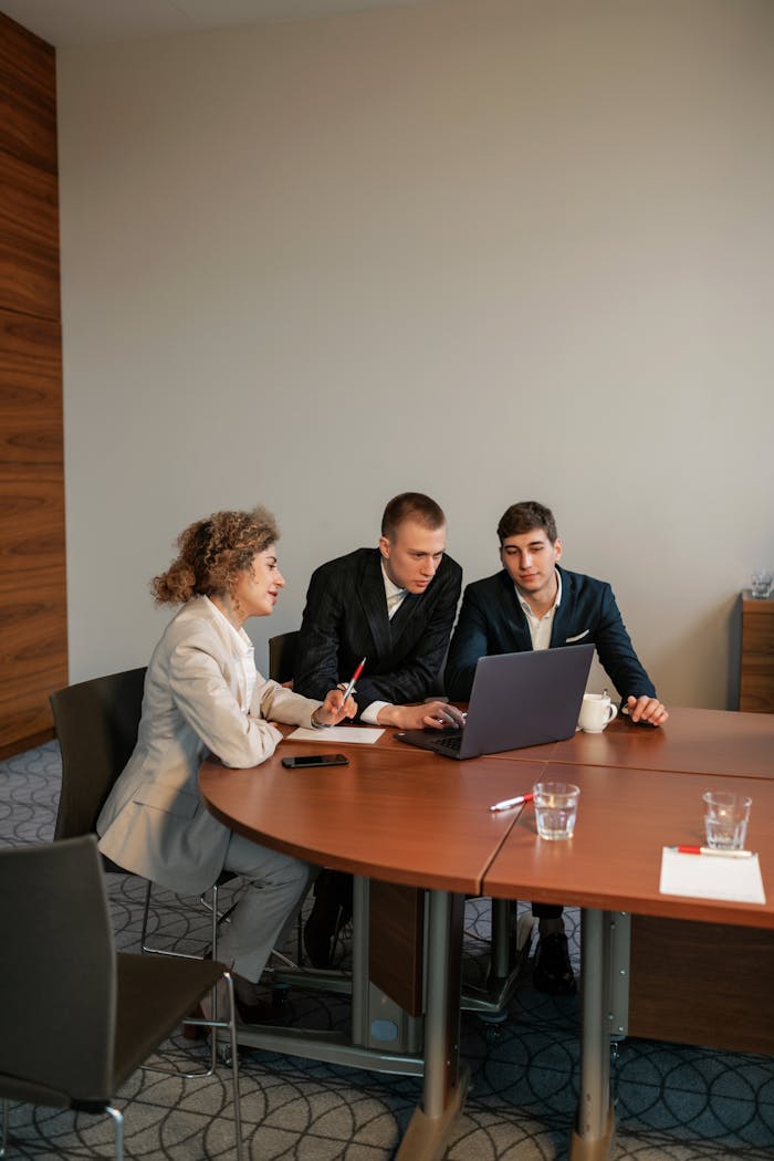 I nostri Servizi Professional setup of three people discussing a project in an office environment.